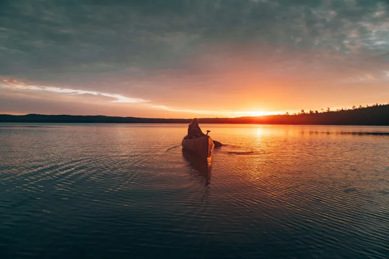 A kayak on calm water at sunset