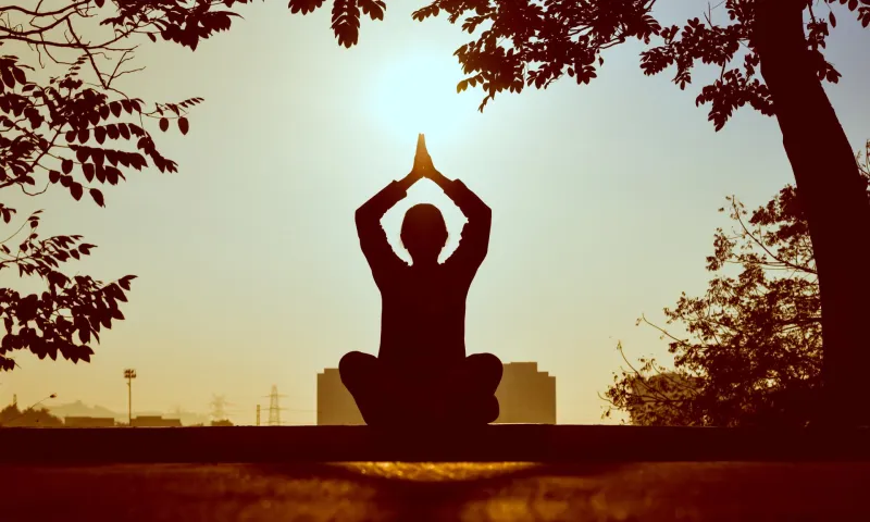 A yoga pose silhouetted against the sunset