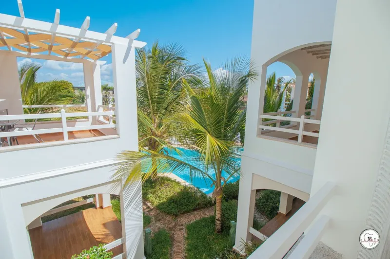 A balcony under a pergola above the pool