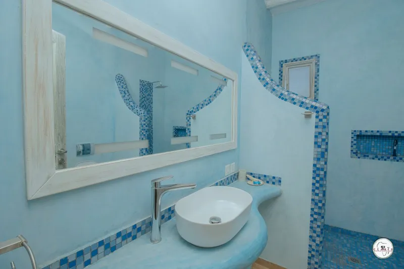 A blue tiled bathroom with a vessel basin
