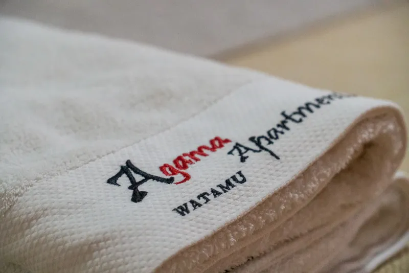 An Agama Apartments towel, embroidered with the logo