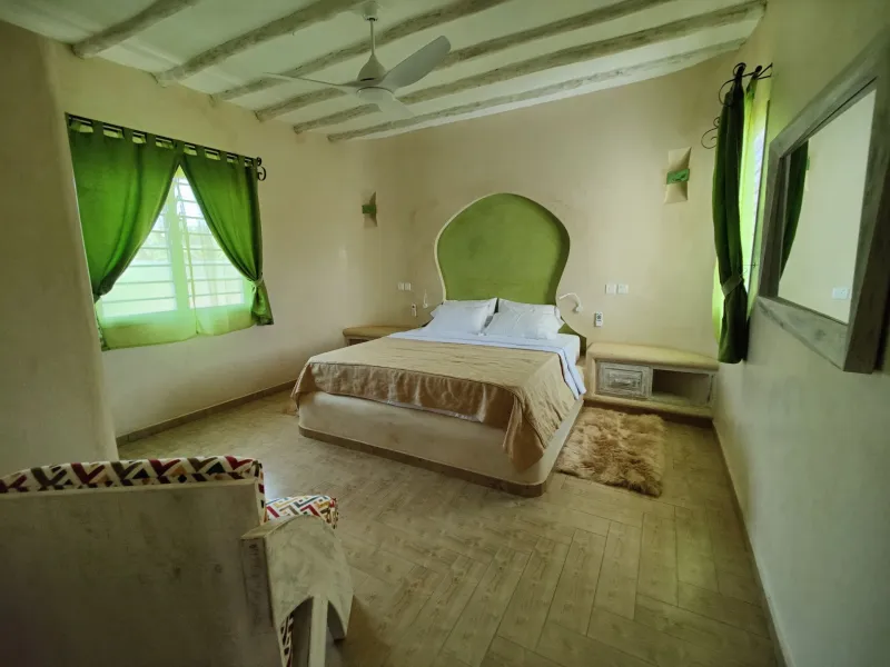 A villa bedroom with green curtains