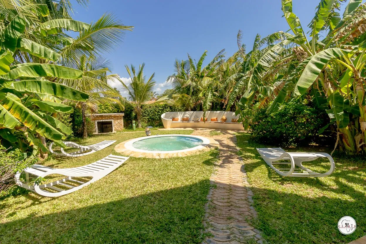 The villa garden with its private Jacuzzi and loungers among banana palms